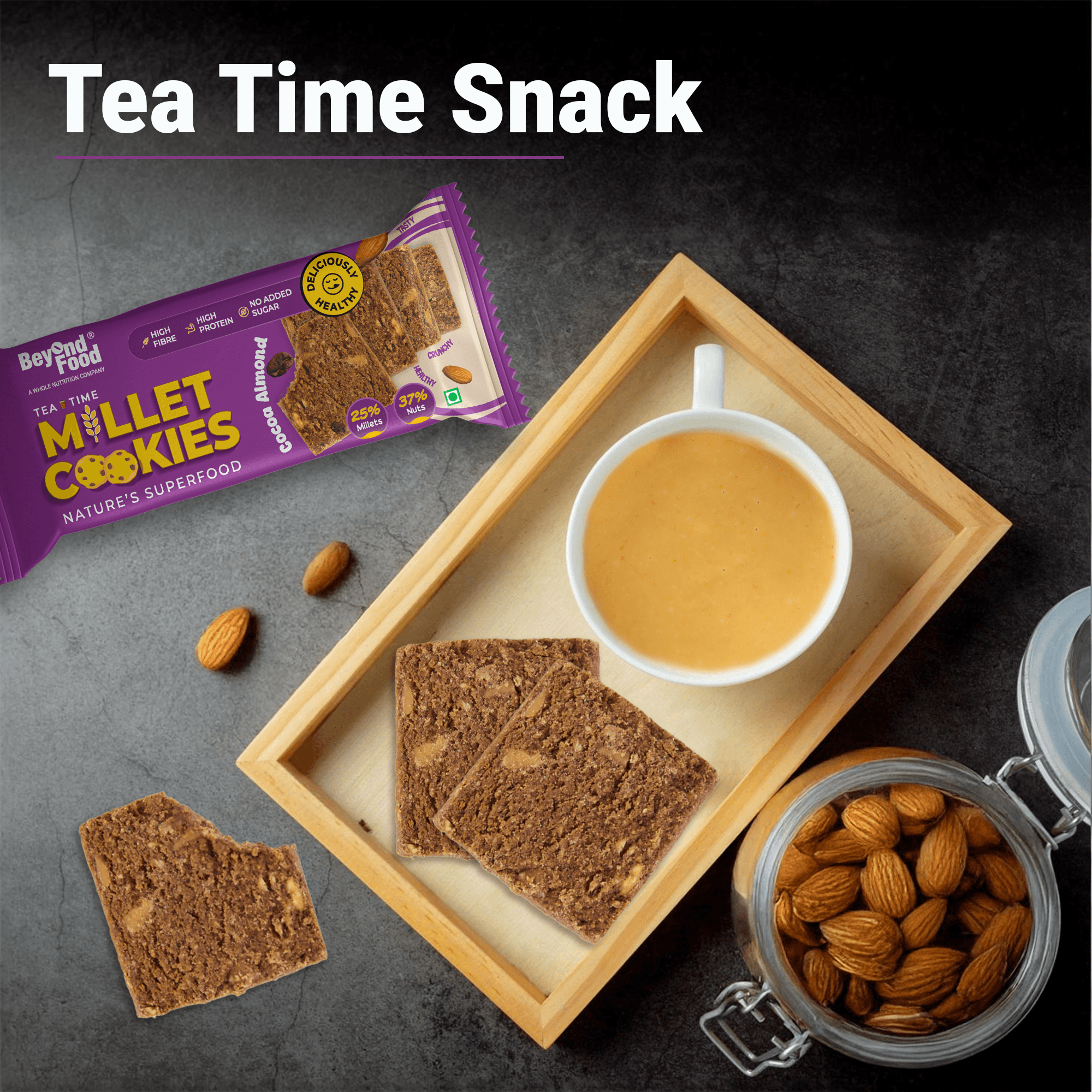 “Wooden tray with a cup of tea, two millet cookies, almonds, and Beyond Food Millet Cookies pack labeled Tea Time Snack.”
